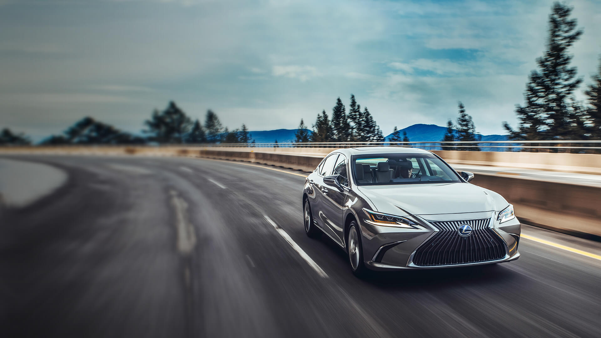 Silver Lexus ES being driven on the road.