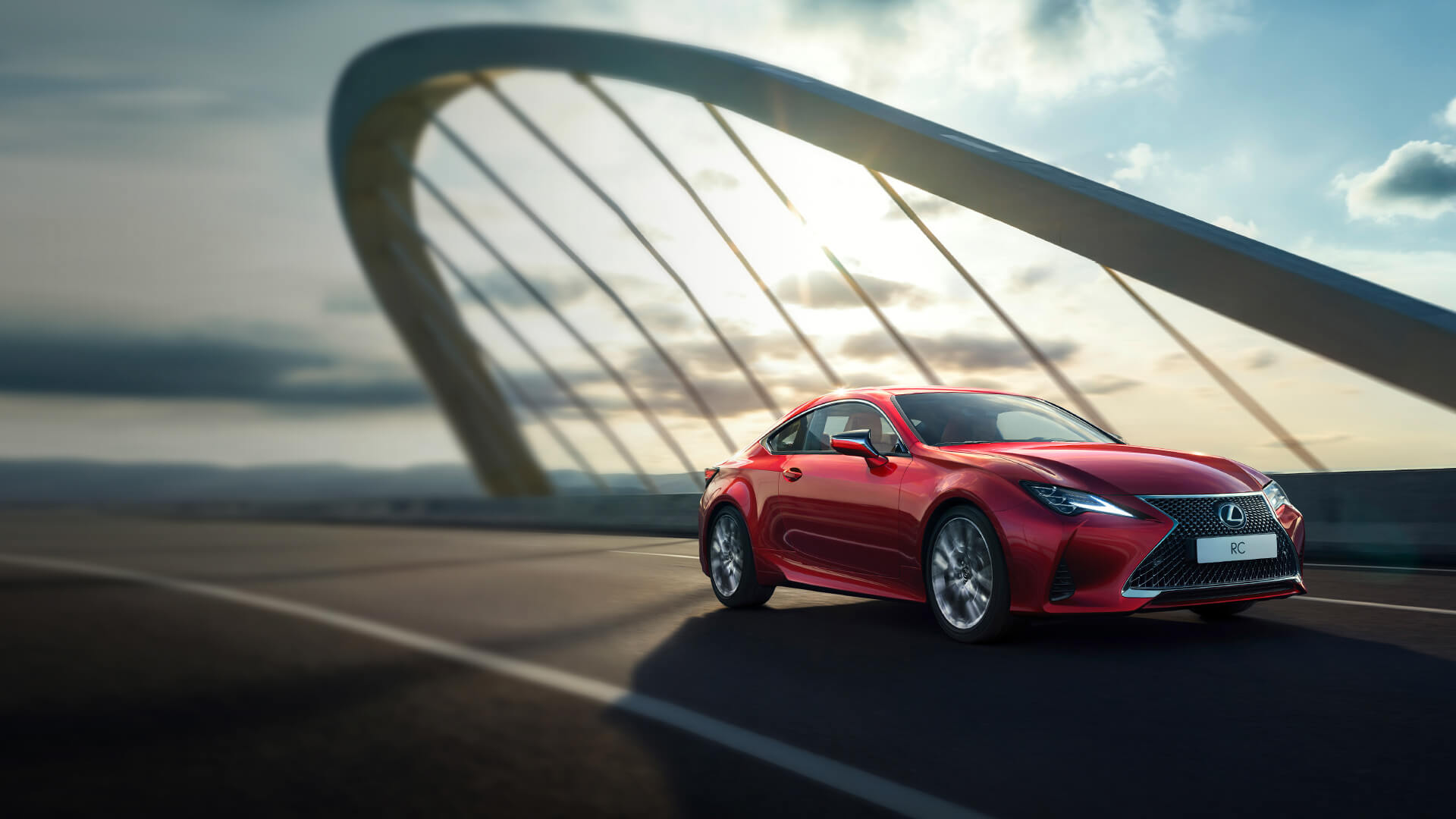 Red Lexus RC being driven on a bridge.