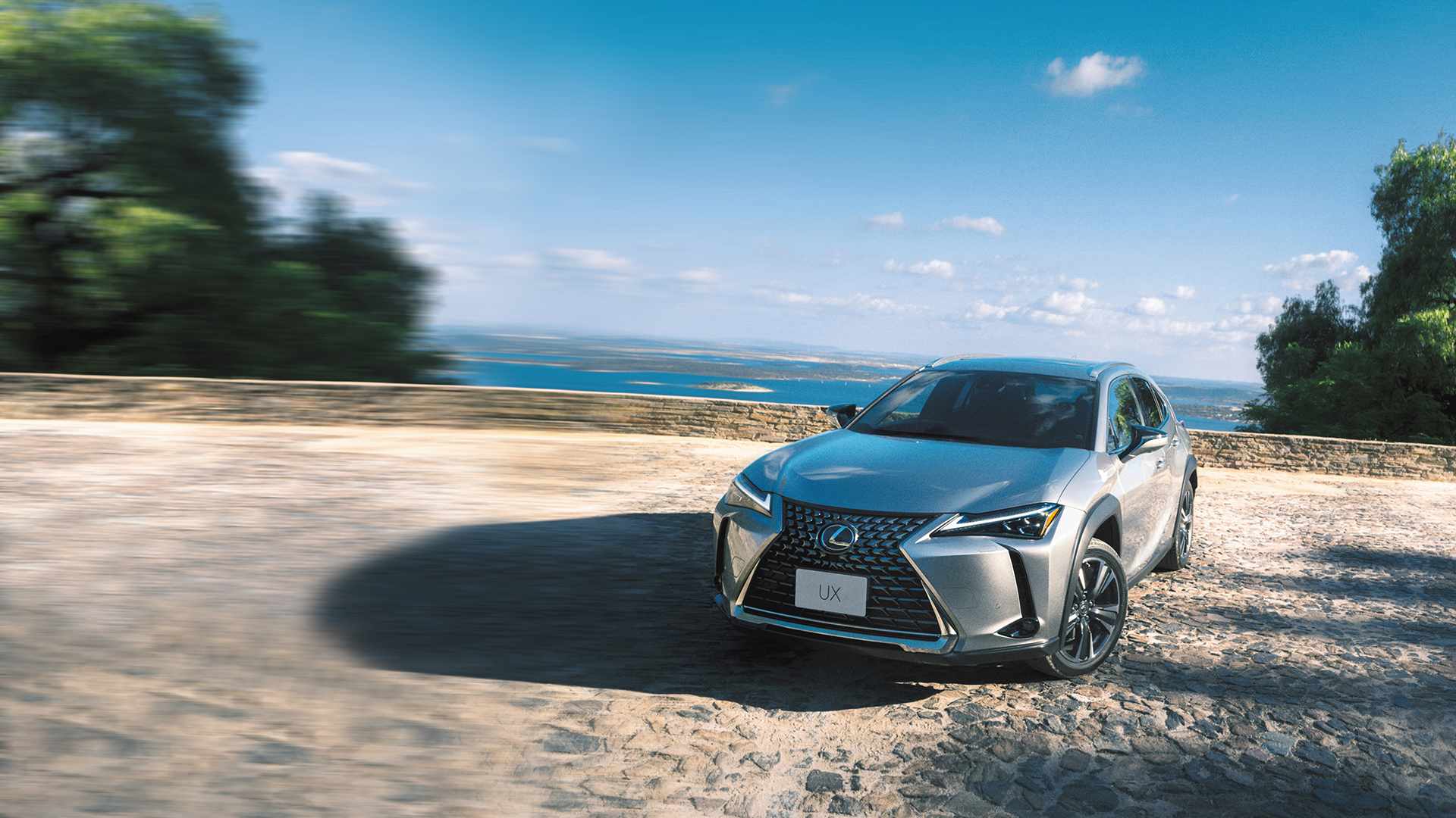 Silver Lexus UX parked next to a lake