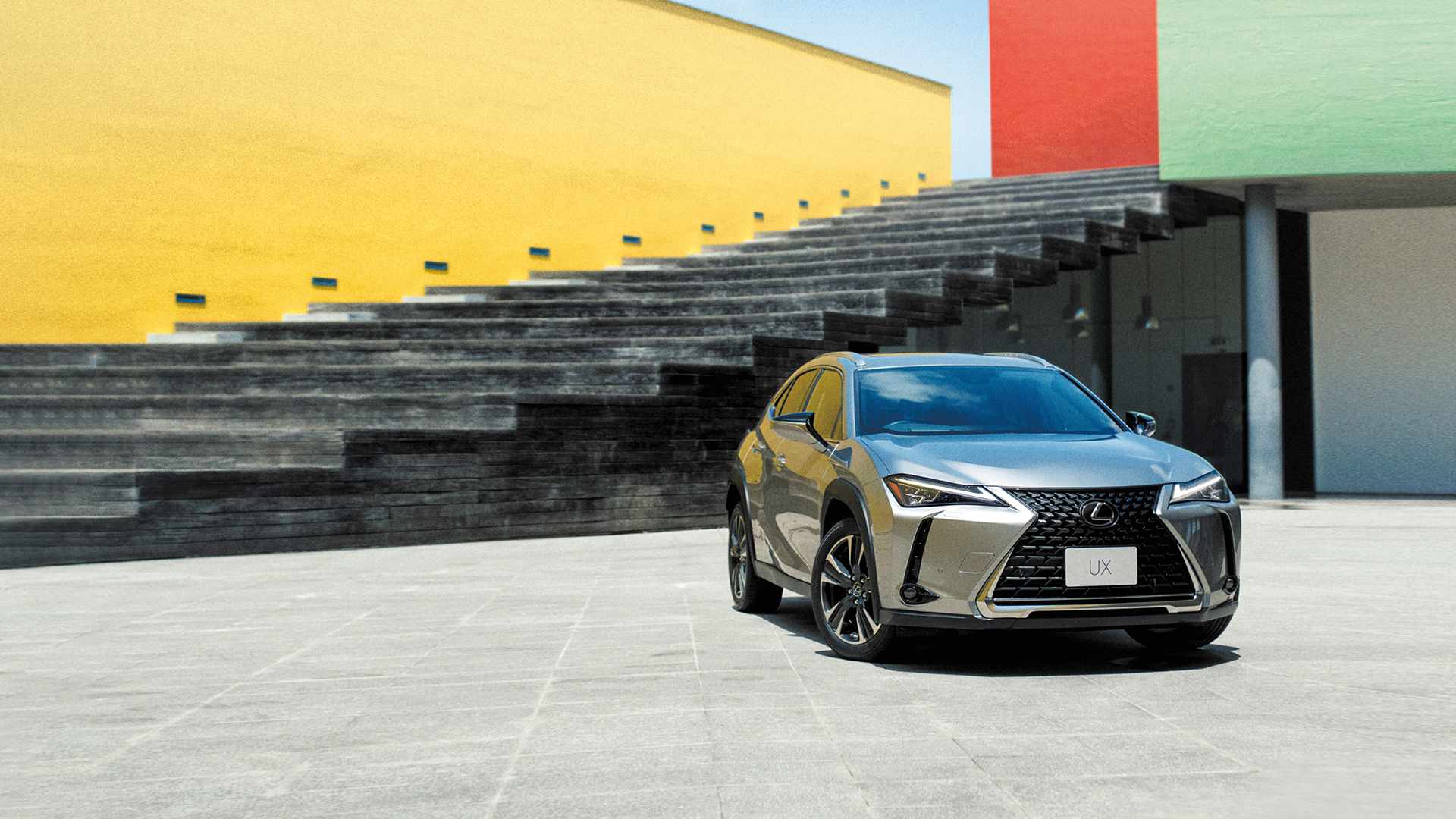 Silver Lexus UX parked in front of a colorful background